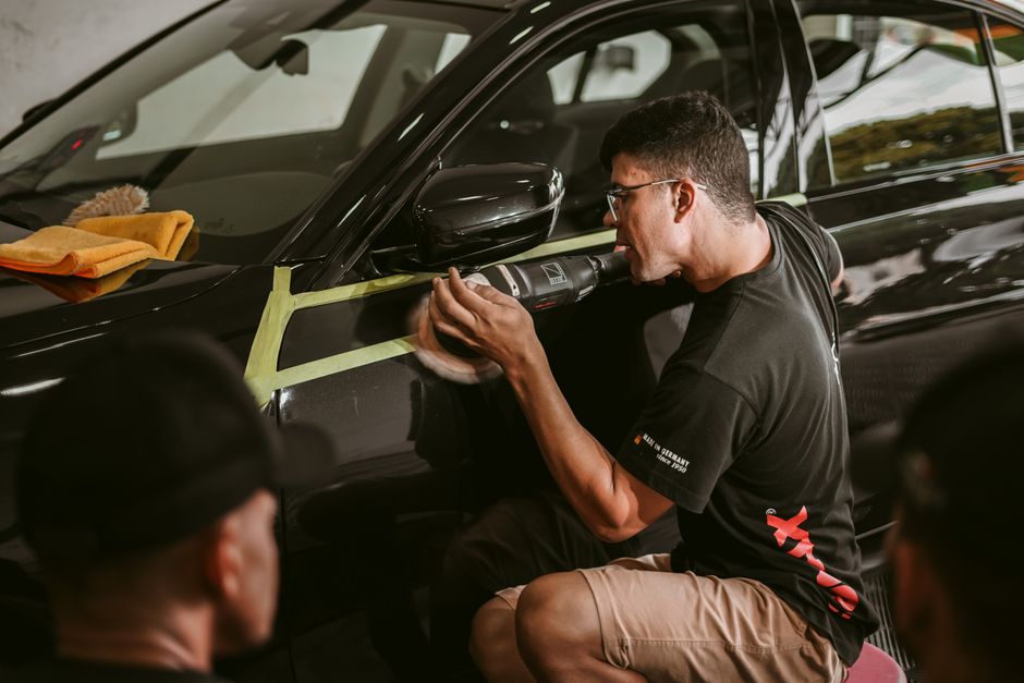 Auto detailer carefully working on vehicle exterior